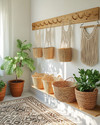 A bright boho mudroom featuring a wooden peg rail with woven baskets and macrame wall hangings, a layered jute and patterned rug, and potted green plants in terracotta pots, all bathed in natural light. — view 4