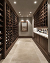 A refined traditional wine cellar featuring dark walnut wine racks, honed travertine flooring, smooth light grey plastered walls, and subtle recessed LED lighting, creating a clean and sophisticated ambiance. — close-up of textures and materials