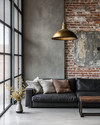 An industrial living room with a cohesive color story featuring a charcoal leather sofa, exposed brick wall, and a large metal-framed window. Warm grey walls, a polished concrete floor, and an aged brass pendant light add to the calm, urban aesthetic. — alternate angle