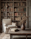 Farmhouse library with a large built-in bookshelf filled with books, a comfortable armchair upholstered in a warm beige fabric, and a weathered wood coffee table adorned with a vase of dried flowers, all under the soft glow of a bronze-finished floor lamp. — close-up of textures and materials
