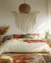 Boho bedroom with a low-slung bed, warm woven rattan pendant light, macrame wall hanging above the bed, and layered textiles in cream, terracotta, and soft green accents. — close-up of textures and materials