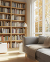 A bright Scandinavian library featuring light oak bookshelves filled with diverse books, a comfortable grey fabric sofa with a beige knit throw, a minimalist white side table, and a large window letting in natural light. — close-up of textures and materials