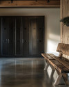 Minimalist industrial mudroom with matte black steel lockers, a polished concrete floor, and a reclaimed oak bench, illuminated by natural light. — alternate angle