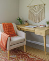 A cozy boho home office with a light wood desk, a macramé wall hanging, and a comfortable armchair, featuring a jute rug and a vibrant terracotta throw, designed for family and pet-friendly living. — close-up of textures and materials
