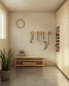 A small Japandi garage featuring light birch plywood cabinetry, a polished concrete floor, and walls painted in a soft off-white. A minimalist bamboo storage bench sits against one wall, with a single snake plant in a grey ceramic pot. Wall-mounted racks hold neatly organized tools, and a bicycle is suspended, maximizing floor space. — close-up of textures and materials