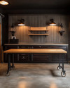A traditional garage interior featuring a solid oak workbench, dark walnut storage cabinets with oil-rubbed bronze hardware, concrete flooring mimicking natural stone, and black iron industrial sconces.