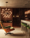 Mid-Century Modern wine cellar featuring a walnut Eames Lounge Chair, a Sputnik chandelier, sleek teak wine racks, and a concrete tasting bar with green upholstered stools.