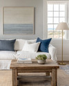 Coastal Landscape living room blending vintage and modern elements, featuring a reclaimed teak coffee table, a linen slipcover sofa, and a brushed brass floor lamp, with walls painted in a soft Balboa Mist grey and accents of deep ocean blue and coral.