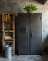 Industrial baby and kids room with a dark gray metal locker, a reclaimed wood pallet bookshelf, and a galvanized metal storage bucket on a concrete-effect accent wall. — alternate angle