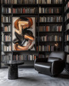 A modern library featuring floor-to-ceiling matte black bookshelves filled with books, a low-profile charcoal leather armchair, a black marble side table, and a large abstract art piece on a wall painted in Benjamin Moore's Gray Owl, with warm task lighting. — close-up of textures and materials