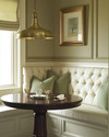 A cozy traditional breakfast nook featuring a built-in cream banquette with sage green cushions, a round dark wood pedestal table, and a classic brass pendant light, all bathed in soft morning light. — alternate angle