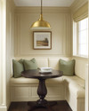 A cozy traditional breakfast nook featuring a built-in cream banquette with sage green cushions, a round dark wood pedestal table, and a classic brass pendant light, all bathed in soft morning light. — close-up of textures and materials