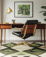 A Mid-Century Modern home office featuring a sleek walnut desk, an Eames Aluminum Group chair in black leather, a geometric area rug with olive green accents, and a brass desk lamp. — view 2