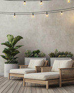 A minimalist boho deck featuring light teak wood lounge chairs with off-white cushions, subtle woven rattan accents, and large concrete planters holding a Fiddle-Leaf Fig and various succulents, all under warm string lights. — styling and décor detail