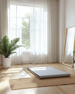 A Scandinavian home gym designed for a seasonal refresh, featuring light wood flooring, white walls, and a large window with sheer curtains. A natural jute rug is placed under a light grey yoga mat, with a potted fern in a white ceramic planter and a simple birch-framed mirror nearby. — close-up of textures and materials