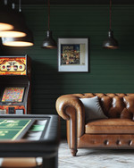 Rustic game room showcasing a blend of vintage and modern elements, with deep forest green walls, a classic leather chesterfield sofa, a vintage arcade machine, and industrial pendant lights illuminating a sleek poker table. — alternate angle