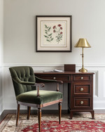 A traditional small home office featuring a dark wood secretary desk with a brass lamp, a comfortable upholstered desk chair in deep green, and a classic Persian rug in muted red and cream tones. A framed botanical print hangs on the wall. — styling and décor detail