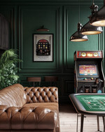 Rustic game room showcasing a blend of vintage and modern elements, with deep forest green walls, a classic leather chesterfield sofa, a vintage arcade machine, and industrial pendant lights illuminating a sleek poker table.