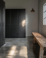 Minimalist industrial mudroom with matte black steel lockers, a polished concrete floor, and a reclaimed oak bench, illuminated by natural light. — close-up of textures and materials