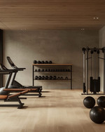 A clean rustic home gym featuring light reclaimed wood flooring, a smooth concrete accent wall, a simple black wrought iron shelf, and minimalist workout equipment with wooden and leather details, bathed in soft ambient lighting. — close-up of textures and materials