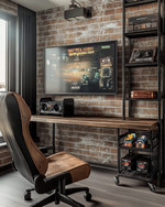 A compact industrial game room featuring a wall-mounted wooden desk with a large monitor, exposed brick wallpaper, and black metal shelving holding retro consoles. A distressed leather gaming chair sits in front, with a small industrial-style bar cart to the side. — alternate angle