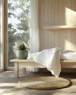 A compact Scandinavian poolhouse interior featuring light birch wood furniture, a white linen throw on a simple bench, and a small round jute rug. A ceramic planter with a green succulent sits on a minimalist shelf, reflecting natural light from a large window. — close-up of textures and materials