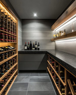 Modern wine cellar with warm grey walls, rift-sawn oak wine racks, and a honed black granite tasting counter. Integrated LED strip lighting illuminates the wine bottles, while recessed spotlights provide ambient glow. — close-up of textures and materials