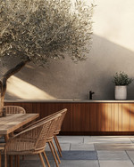 Japandi outdoor kitchen featuring untreated teak cabinetry, honed concrete countertops, and bluestone pavers. Minimalist rattan dining chairs surround a solid wood table, with an olive tree in an unglazed ceramic planter providing a natural accent. — close-up of textures and materials