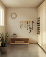 A small Japandi garage featuring light birch plywood cabinetry, a polished concrete floor, and walls painted in a soft off-white. A minimalist bamboo storage bench sits against one wall, with a single snake plant in a grey ceramic pot. Wall-mounted racks hold neatly organized tools, and a bicycle is suspended, maximizing floor space. — close-up of textures and materials