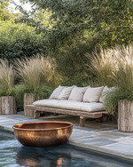 A rustic poolside area featuring a reclaimed timber bench with linen cushions, large natural stone planters filled with tall grasses, and a hammered copper fire bowl, all set against a backdrop of natural stone paving and lush greenery. — close-up of textures and materials