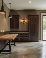 A traditional garage interior featuring a solid oak workbench, dark walnut storage cabinets with oil-rubbed bronze hardware, concrete flooring mimicking natural stone, and black iron industrial sconces. — close-up of textures and materials