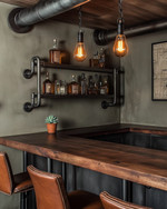 An inviting industrial home bar featuring a reclaimed wood countertop, dark metal pipe shelving, and leather bar stools. Warm Edison bulb pendants cast an amber glow, highlighting vintage amber glass bottles and a small potted succulent. — close-up of textures and materials
