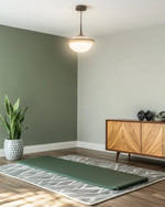 Mid-Century Modern home gym with a muted olive green accent wall, light gray walls, a Sputnik-style pendant light, and a teak-veneered credenza. A yoga mat is laid out on a geometric wool rug, with a snake plant in a ceramic planter. — styling and décor detail