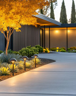 A Mid-Century Modern driveway featuring a broom-finished concrete surface, bordered by low-maintenance agave and sedum plants. Sleek, mushroom-style path lights illuminate the edge, while a Japanese maple provides subtle shade. — close-up of textures and materials