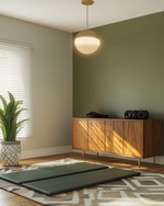 Mid-Century Modern home gym with a muted olive green accent wall, light gray walls, a Sputnik-style pendant light, and a teak-veneered credenza. A yoga mat is laid out on a geometric wool rug, with a snake plant in a ceramic planter. — close-up of textures and materials