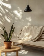 A Scandinavian porch featuring a light ash slatted bench with a cream knit throw, a small round teak coffee table, and a sculptural snake plant in a terracotta pot, all under the soft glow of a matte black outdoor pendant light.