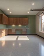 Clean Mid-Century Modern garage featuring walnut flat-panel cabinetry, a polished light grey epoxy floor, recessed LED lighting, and a subtle sage green accent wall behind a minimalist workbench. — close-up of textures and materials