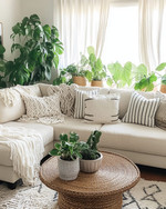 A cozy boho family room featuring a cream sectional sofa adorned with macrame and striped throw pillows, a round rattan coffee table, and an abundance of lush green plants in woven and ceramic planters, all bathed in natural light from a large window with sheer linen curtains. — close-up of textures and materials