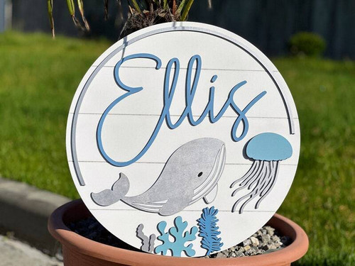 Whale nursery sign, personalized round wood wall art for baby's room, ocean theme with custom name on natural wood grain | Family Wall Decor