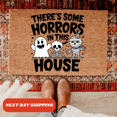 Halloween doormat with 'There's Some Horror In This House' text, coir coconut fiber, black script, spooky front porch decor | Familywalldecor