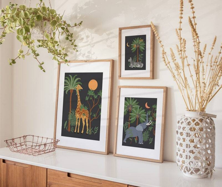 Safari animal canvas set with tropical leaves background, square prints in earthy tones for jungle nursery decor.