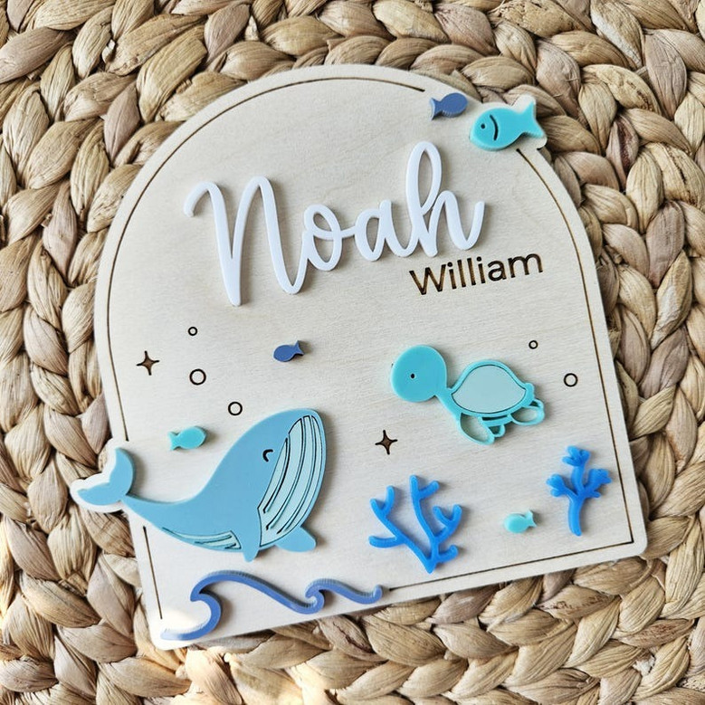 Whale nursery wood sign, round teal-stained plaque personalized with baby name and stats for ocean nursery decor