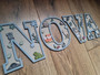 Woodland nursery animal wood sign letters, painted gray, cursive name with owl and moon, above changing table