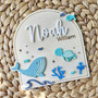 Whale nursery wood sign, round teal-stained plaque personalized with baby name and stats for ocean nursery decor
